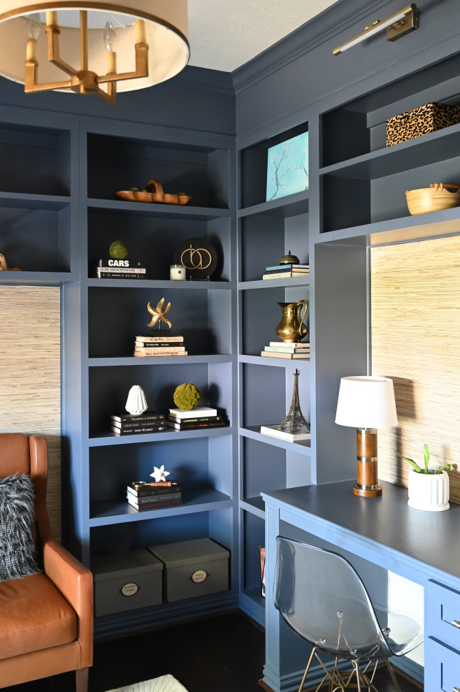 Bild på ett litet maritimt hemmabibliotek, med blå väggar, mörkt trägolv, ett inbyggt skrivbord och brunt golv