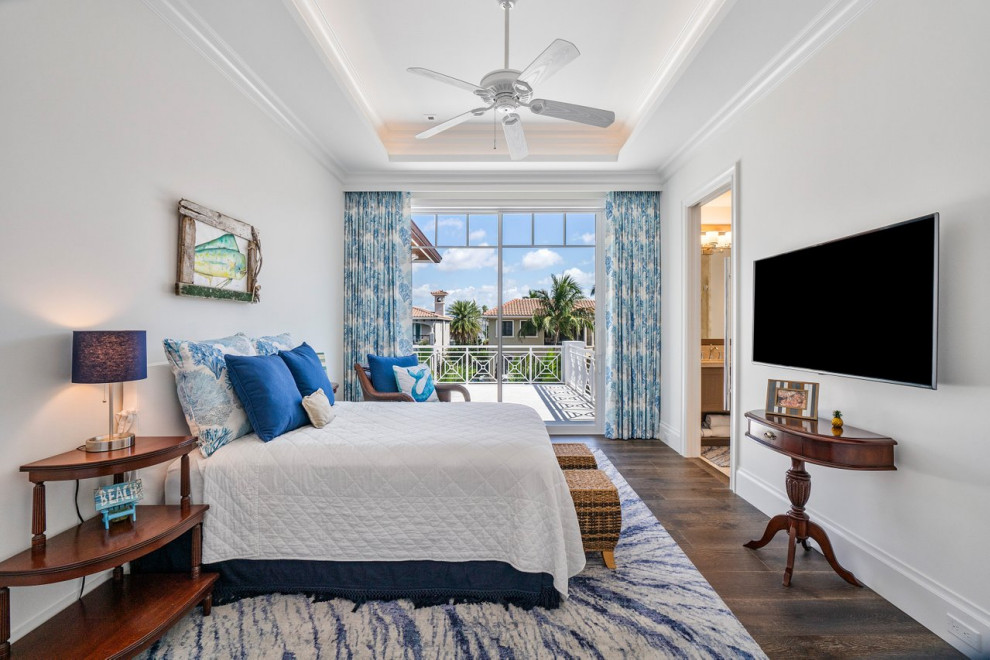 Example of a large beach style master medium tone wood floor, brown floor and vaulted ceiling bedroom design in Miami with white walls