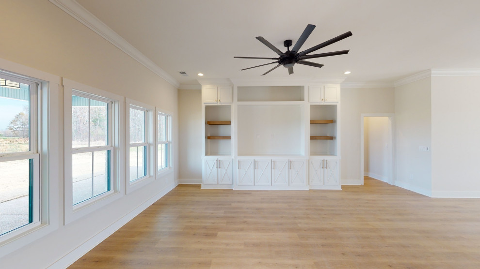 Imagen de sala de estar abierta campestre de tamaño medio con paredes blancas, suelo de madera clara y suelo amarillo
