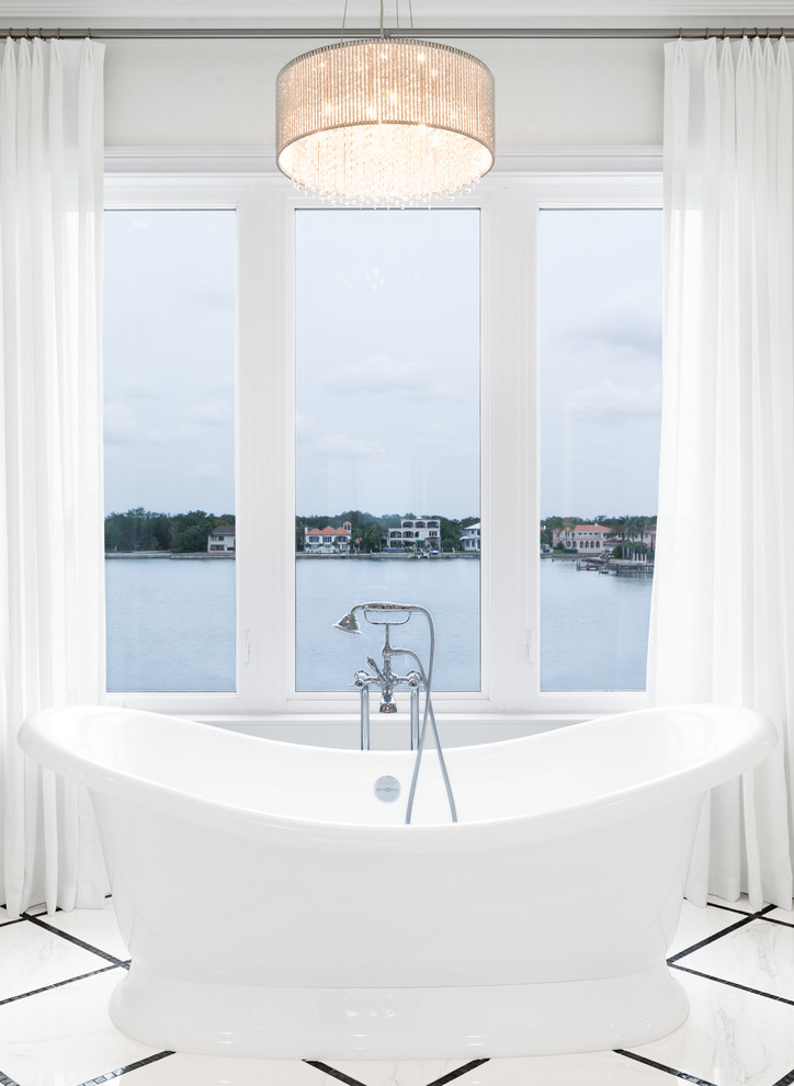 Inspiration for a mid-sized transitional master bathroom in Tampa with white cabinets, a freestanding tub, a corner shower, a one-piece toilet, white tile, porcelain tile, white walls, mosaic tile floors, an undermount sink, white floor, a hinged shower door, raised-panel cabinets and marble benchtops.