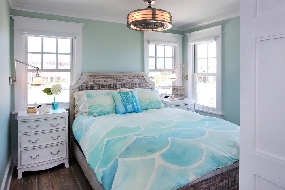 This is an example of a small beach style guest bedroom in Philadelphia with green walls, no fireplace, brown floor and dark hardwood floors.