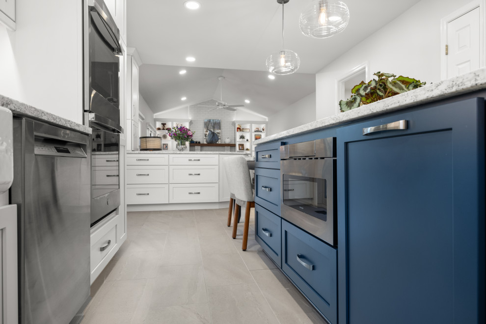 Example of a mid-sized transitional kitchen design in DC Metro with shaker cabinets, white cabinets, quartz countertops, porcelain backsplash, stainless steel appliances and an island