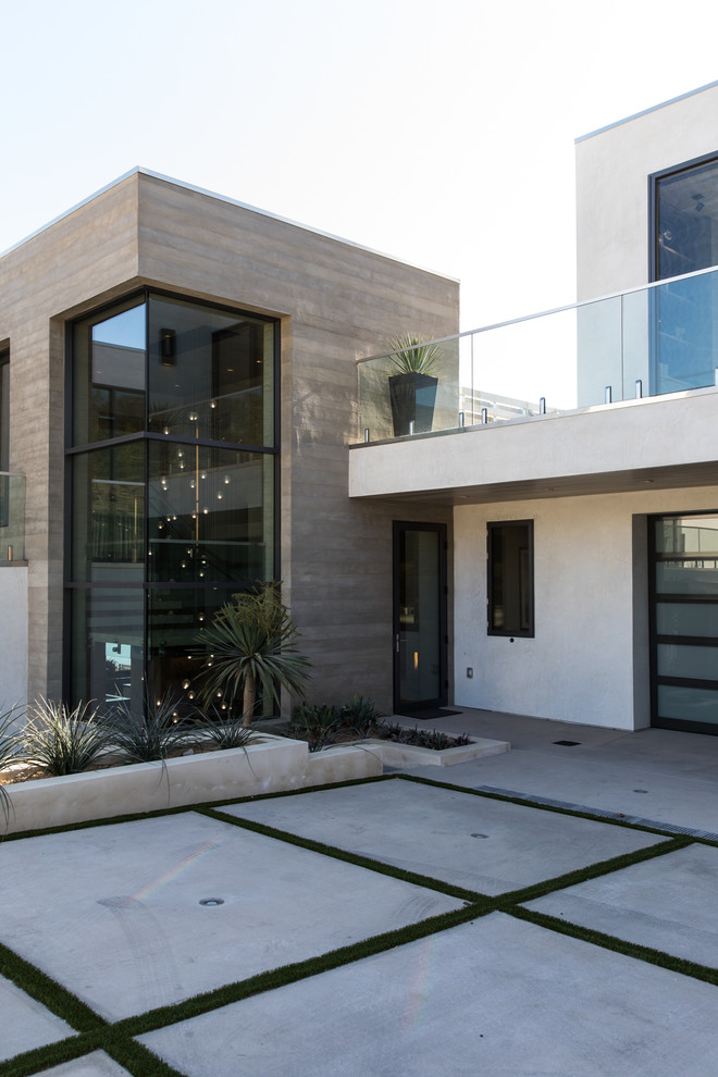 Expansive contemporary three-storey multi-coloured house exterior in Los Angeles with mixed siding and a flat roof.