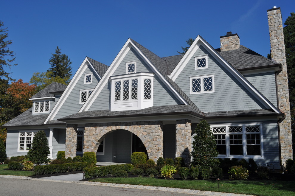 Large traditional two-storey grey exterior in New York with wood siding and a gable roof.