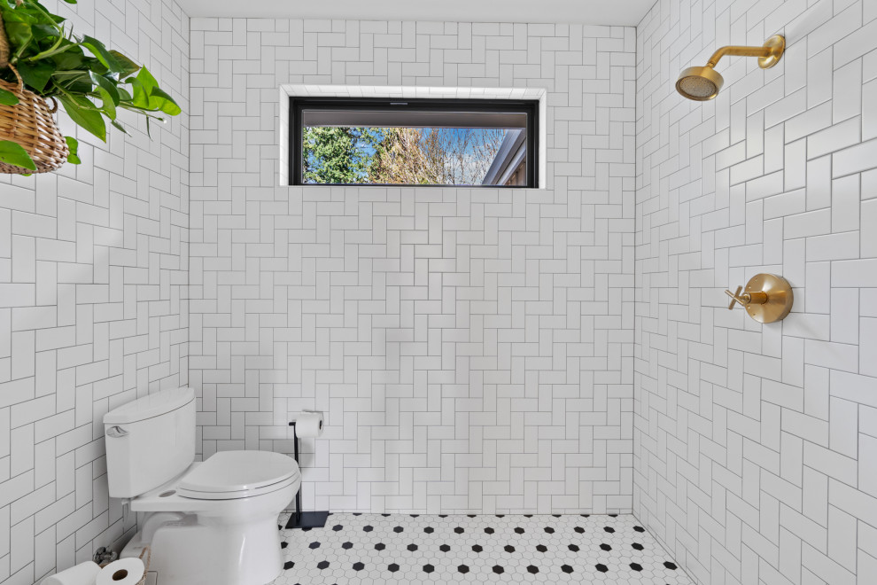Lantlig inredning av ett stort vit vitt badrum med dusch, med skåp i shakerstil, skåp i ljust trä, en kantlös dusch, en toalettstol med hel cisternkåpa, vit kakel, tunnelbanekakel, vita väggar, klinkergolv i keramik, ett undermonterad handfat, bänkskiva i kvartsit, vitt golv och med dusch som är öppen