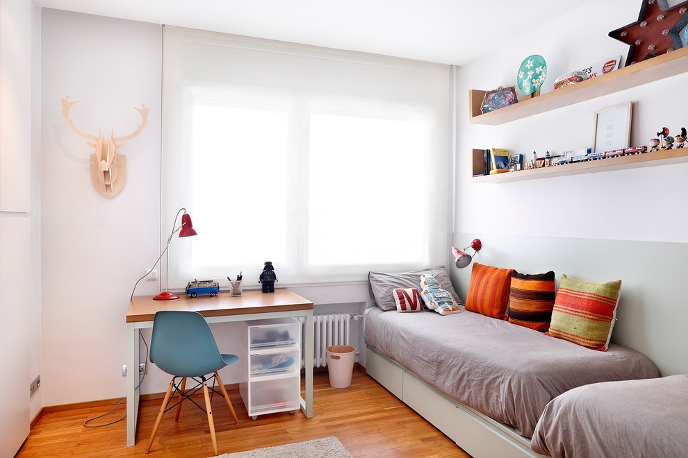 This is an example of a mid-sized contemporary gender-neutral kids' bedroom for kids 4-10 years old in Barcelona with white walls and medium hardwood floors.
