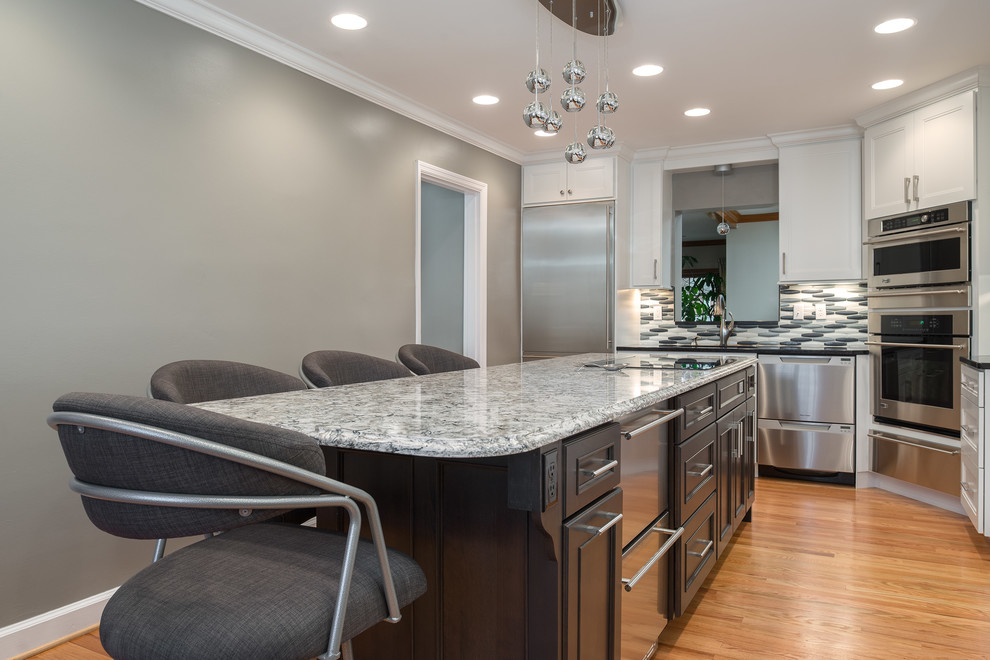 Transitional l-shaped light wood floor eat-in kitchen photo in St Louis with an undermount sink, shaker cabinets, white cabinets, quartz countertops, metallic backsplash, glass tile backsplash, stainless steel appliances and an island