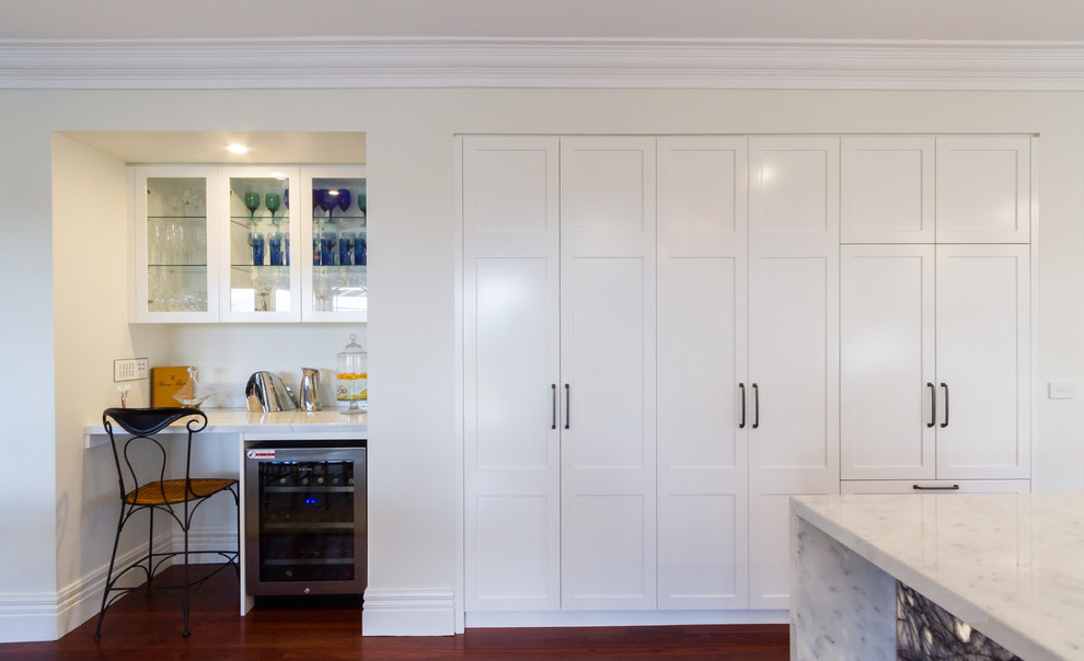 Inspiration for a large contemporary u-shaped eat-in kitchen in Melbourne with an undermount sink, shaker cabinets, white cabinets, marble benchtops, white splashback, window splashback, black appliances, dark hardwood floors, with island, brown floor and white benchtop.