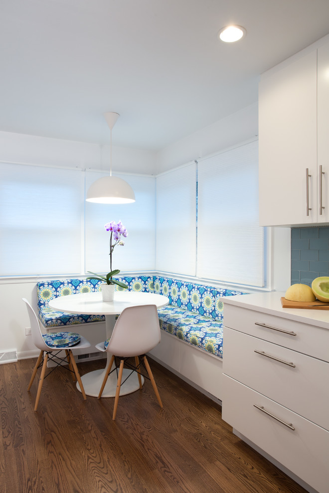 This is an example of a mid-sized modern galley eat-in kitchen in Chicago with an undermount sink, flat-panel cabinets, white cabinets, blue splashback, subway tile splashback, stainless steel appliances, medium hardwood floors, no island and quartz benchtops.
