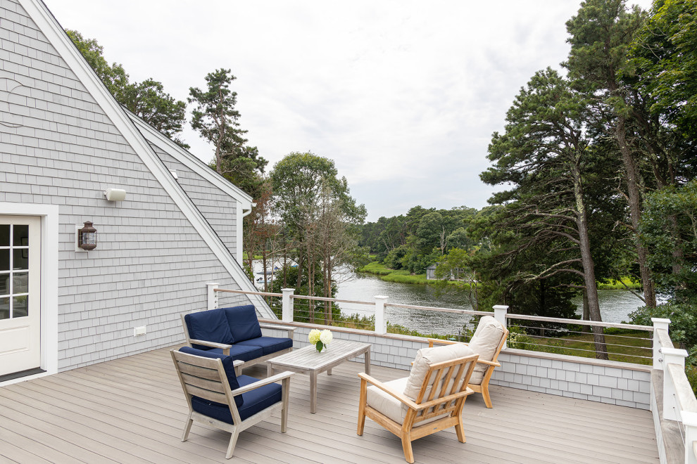 Large beach style rooftop second story cable railing deck photo in Boston