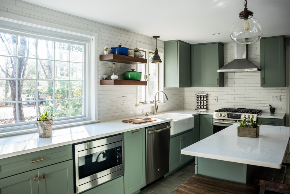Design ideas for an expansive transitional galley kitchen in Philadelphia with a farmhouse sink, flat-panel cabinets, green cabinets, quartzite benchtops, white splashback, ceramic splashback, stainless steel appliances, vinyl floors, with island, brown floor and white benchtop.