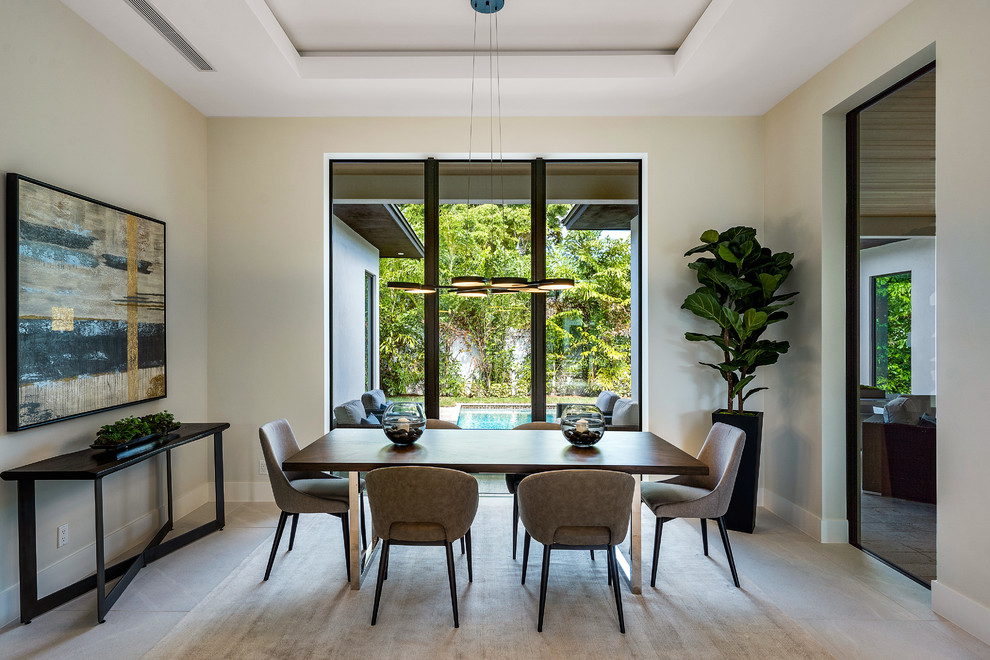 This is an example of a contemporary dining room in Miami with beige walls and grey floor.
