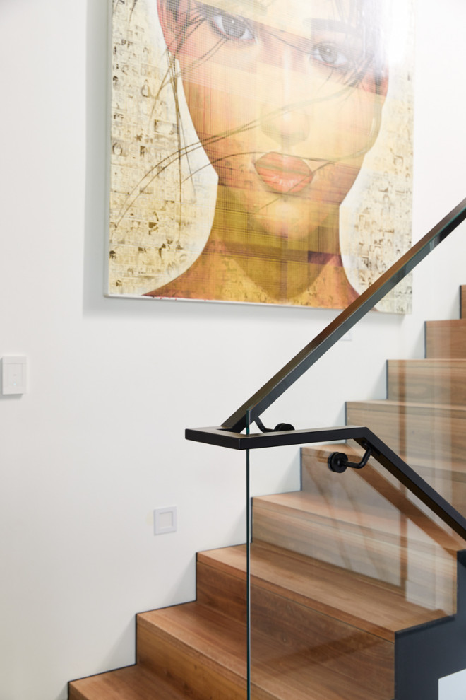 Photo of a large industrial wood u-shaped staircase in Melbourne with wood risers and metal railing.