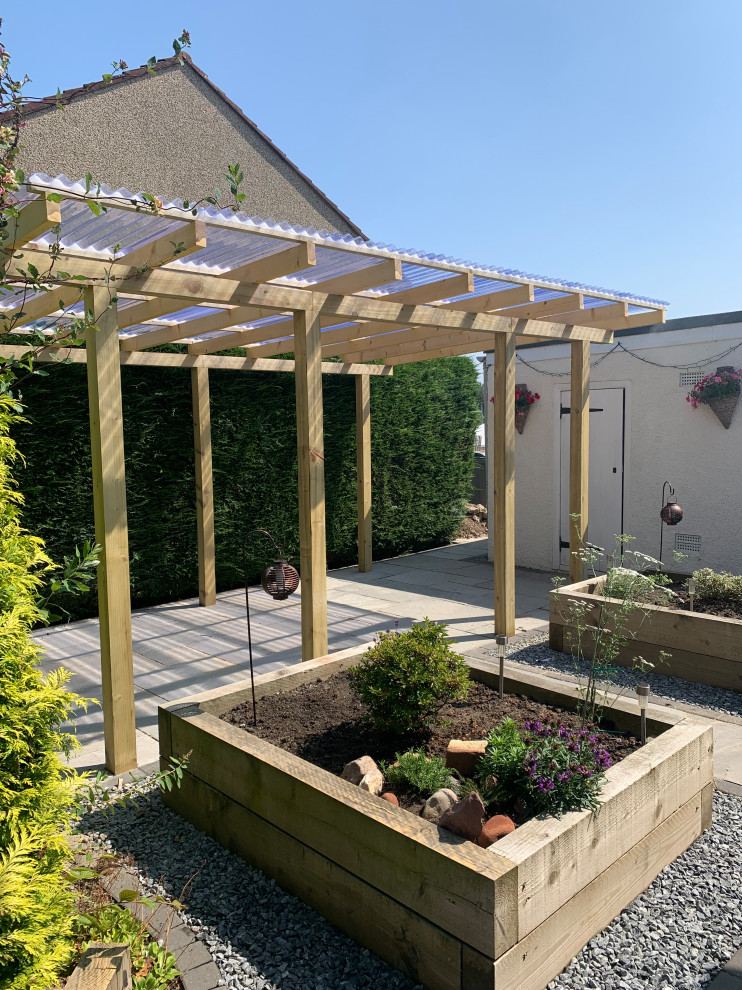 Пример оригинального дизайна: маленький солнечный, весенний регулярный сад на заднем дворе в современном стиле с с перголой, хорошей освещенностью, покрытием из гальки и с деревянным забором для на участке и в саду