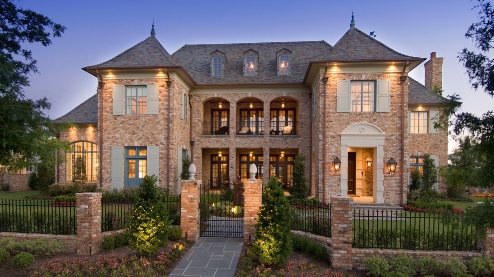 Design ideas for a three-storey brick house exterior in Houston with a hip roof.