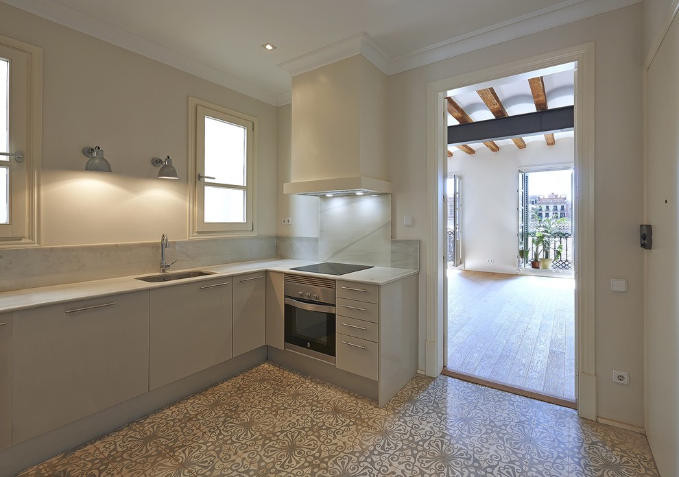 Mid-sized transitional l-shaped separate kitchen in Barcelona with a single-bowl sink, flat-panel cabinets and no island.