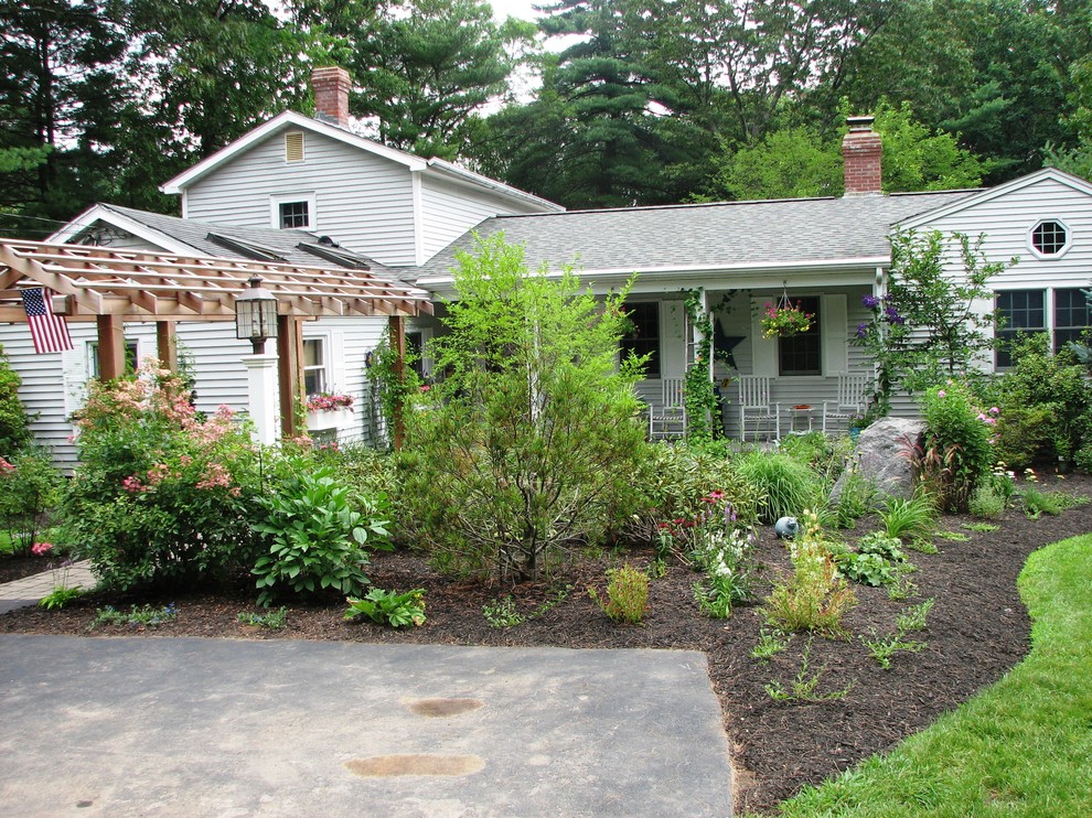 This is an example of a mid-sized traditional front yard full sun formal garden for summer in Boston with a water feature.