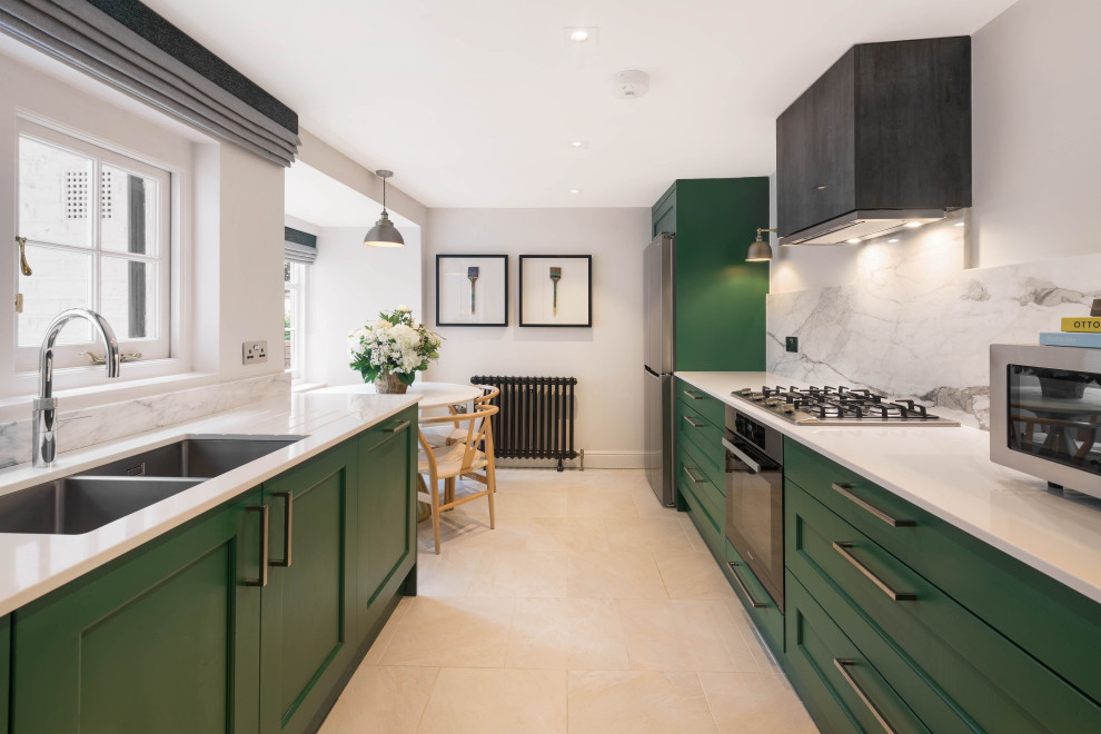 Inspiration for a small classic galley kitchen/diner in London with a double-bowl sink, recessed-panel cabinets, green cabinets, quartz worktops, multi-coloured splashback, marble splashback, stainless steel appliances, ceramic flooring, no island, beige floors and white worktops.