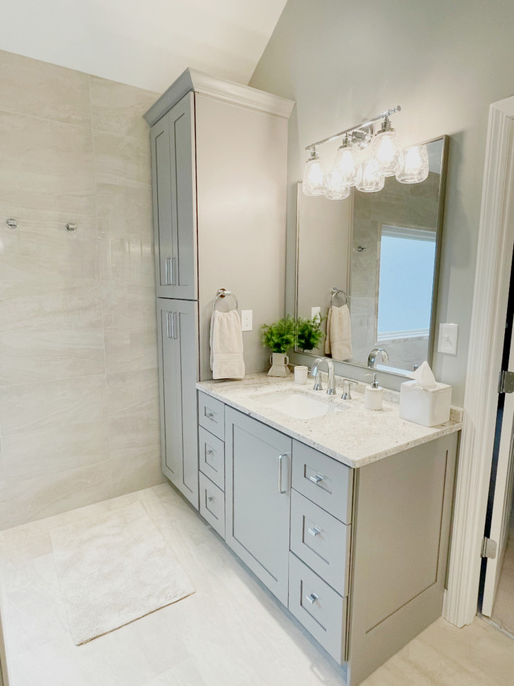 This is an example of a transitional master bathroom in Other with shaker cabinets, grey cabinets, a curbless shower, beige tile, porcelain tile, grey walls, porcelain floors, an undermount sink, granite benchtops, beige floor, an open shower, a niche and a built-in vanity.