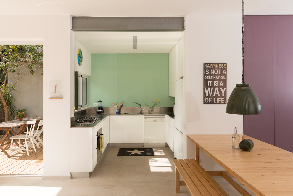 Design ideas for a small contemporary u-shaped kitchen in Tel Aviv with an integrated sink, white cabinets, stainless steel benchtops, metallic splashback, white appliances, ceramic floors and metal splashback.