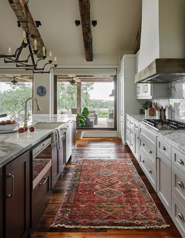 Inspiration for an expansive country single-wall kitchen in Austin with shaker cabinets, white cabinets, stainless steel appliances, medium hardwood floors, with island and exposed beam.