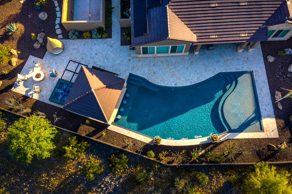 Inspiration for a large backyard stone and custom-shaped hot tub remodel in Phoenix