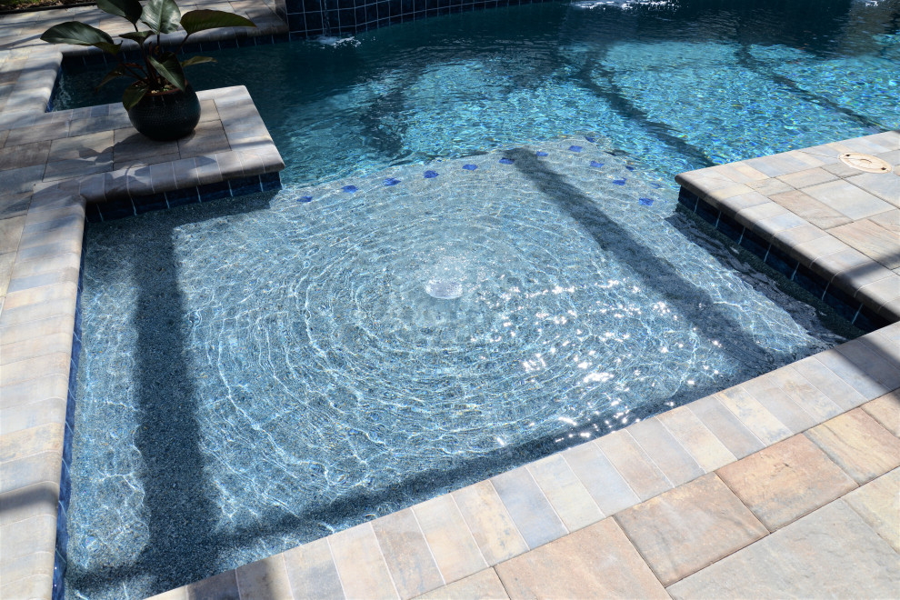Cette image montre une piscine arrière chalet de taille moyenne et rectangle avec des pavés en brique.