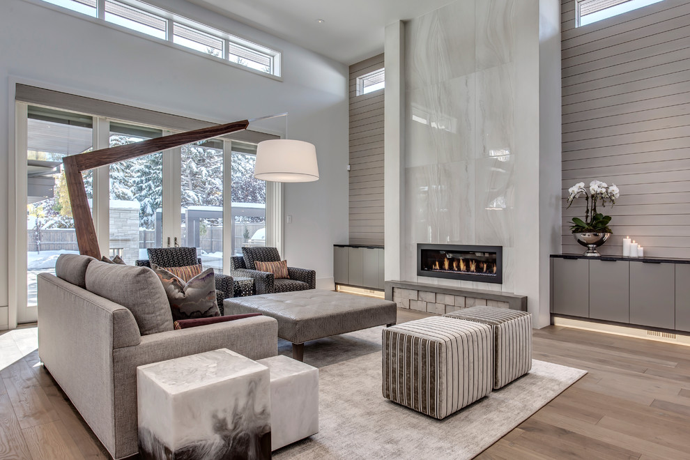 Example of a large trendy open concept light wood floor and beige floor living room design in Calgary with a tile fireplace, no tv, white walls and a ribbon fireplace