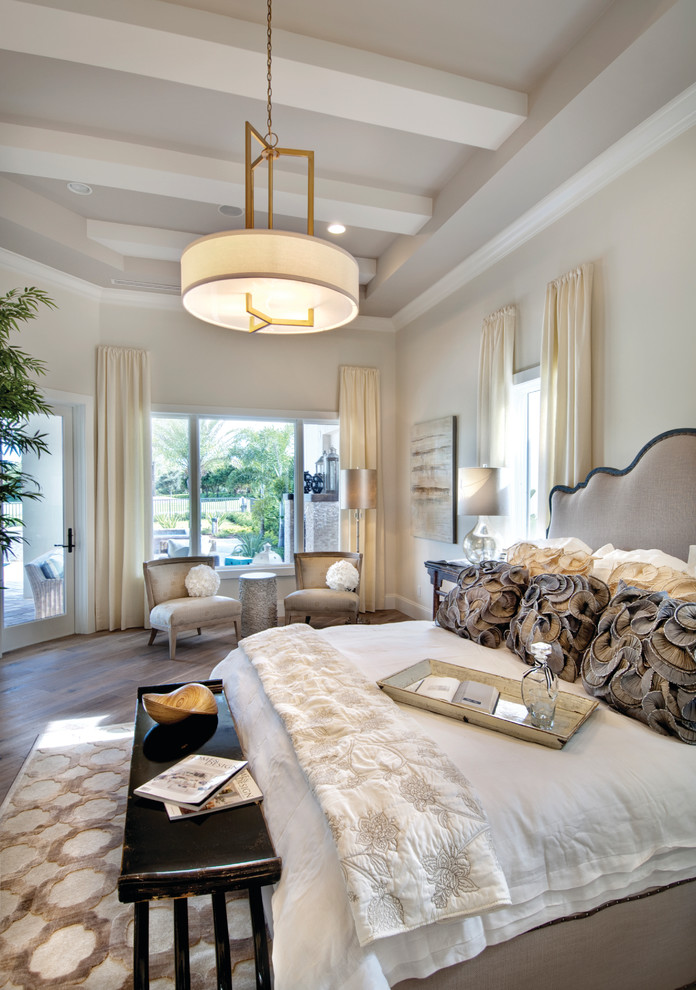 Inspiration for a large mediterranean master bedroom in Miami with beige walls, medium hardwood floors and no fireplace.
