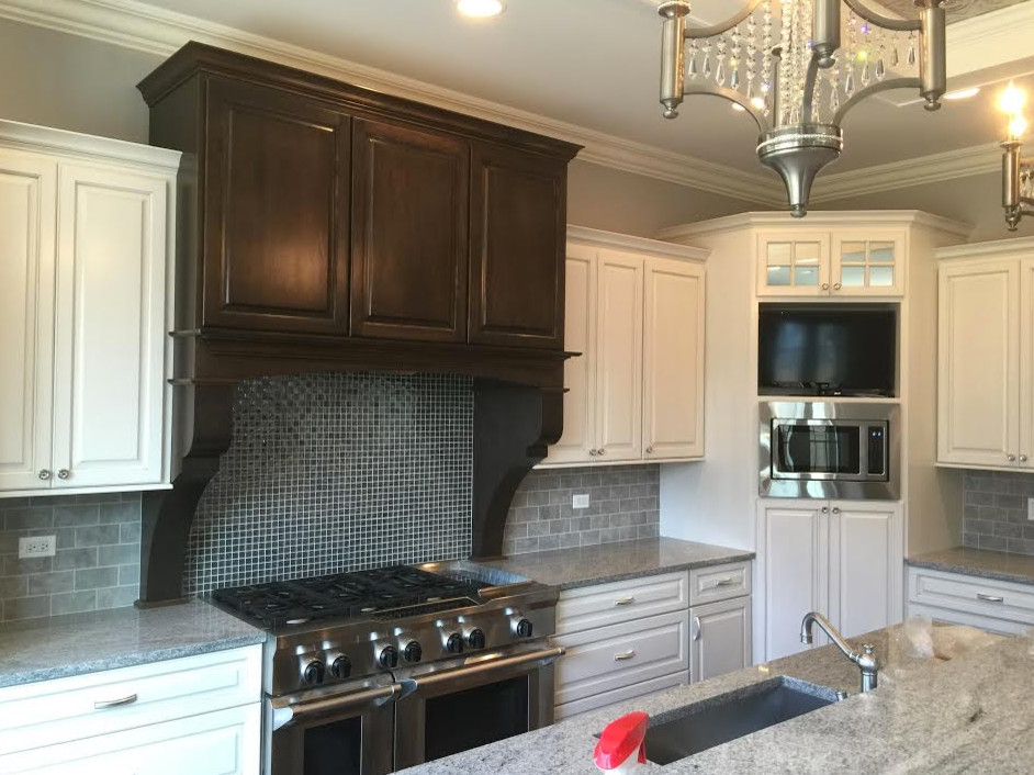 Inspiration for a large transitional l-shaped kitchen remodel in Chicago with an undermount sink, raised-panel cabinets, white cabinets, quartzite countertops, gray backsplash, subway tile backsplash, stainless steel appliances and an island