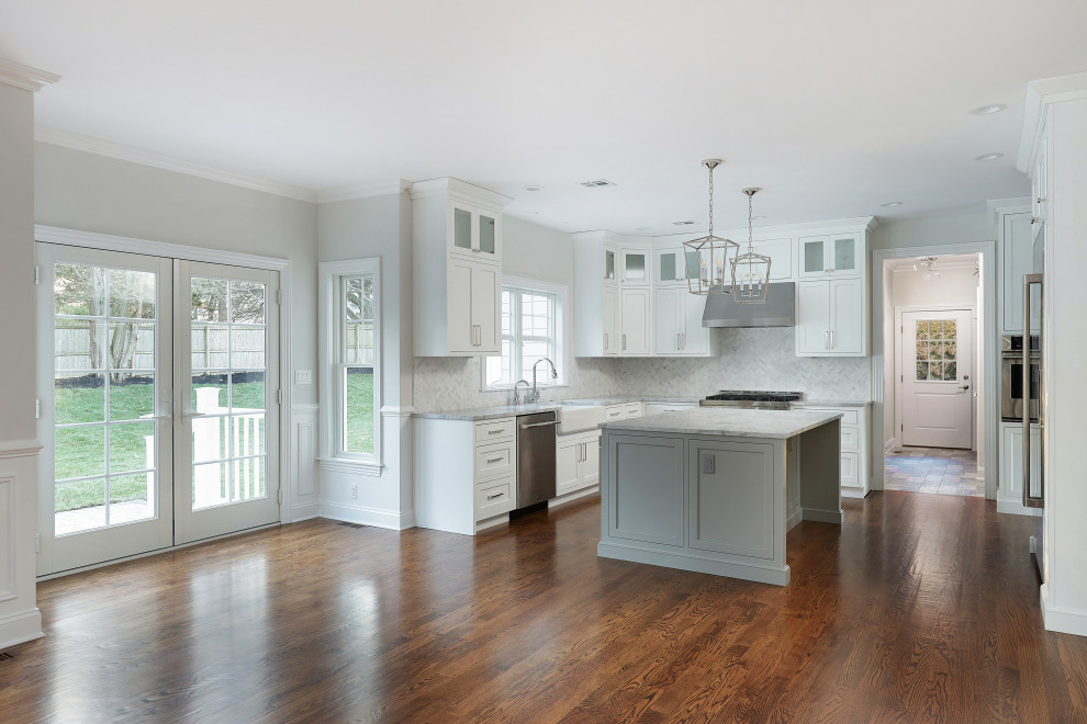 Inspiration for a large transitional u-shaped medium tone wood floor eat-in kitchen remodel with shaker cabinets, white cabinets, stainless steel appliances and an island