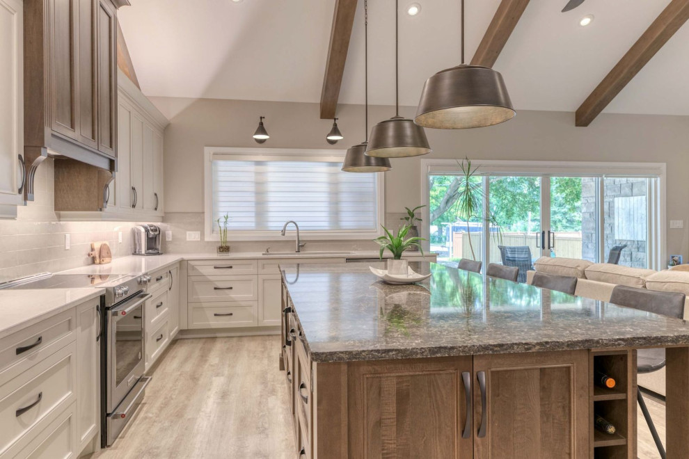 Eat-in kitchen - large transitional eat-in kitchen idea with an undermount sink, shaker cabinets, quartz countertops, porcelain backsplash, stainless steel appliances and an island