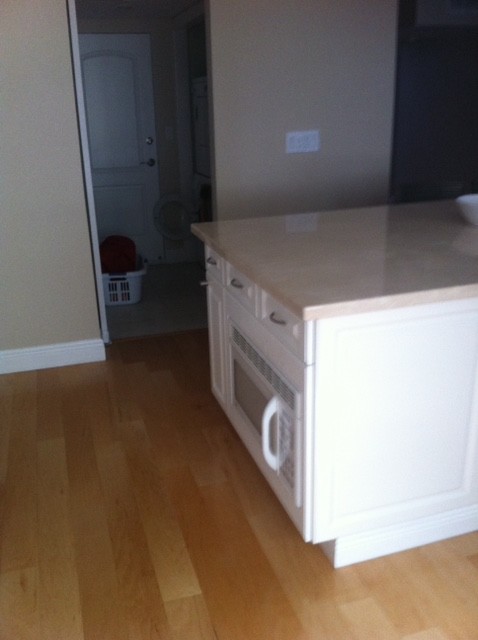Kitchen - transitional light wood floor kitchen idea with recessed-panel cabinets, white cabinets, quartz countertops, stone tile backsplash, white appliances and an island