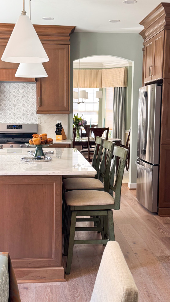 Eat-in kitchen - mid-sized coastal light wood floor eat-in kitchen idea in Baltimore with recessed-panel cabinets, medium tone wood cabinets, quartzite countertops, stainless steel appliances, an island and white countertops