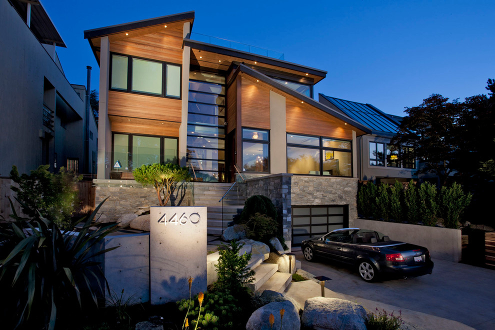 This is an example of a mid-sized contemporary two-storey brown house exterior in Vancouver with wood siding, a shed roof and a metal roof.