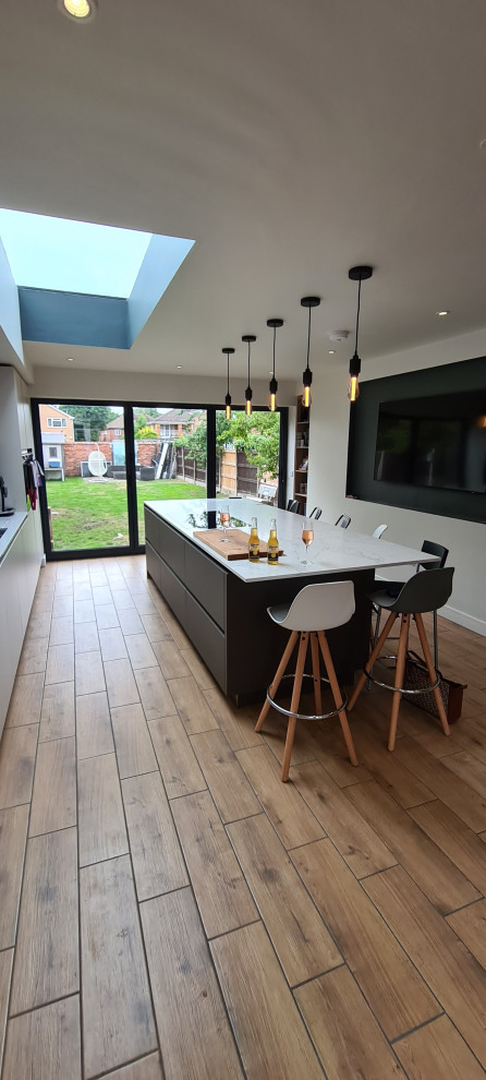 Design ideas for a large contemporary grey and white single-wall open plan kitchen with flat-panel cabinets and an island.