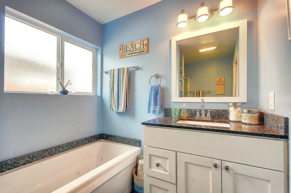 Inspiration for a mid-sized transitional 3/4 bathroom in San Francisco with shaker cabinets, white cabinets, an alcove shower, a two-piece toilet, beige tile, blue walls, porcelain floors, an undermount sink and granite benchtops.