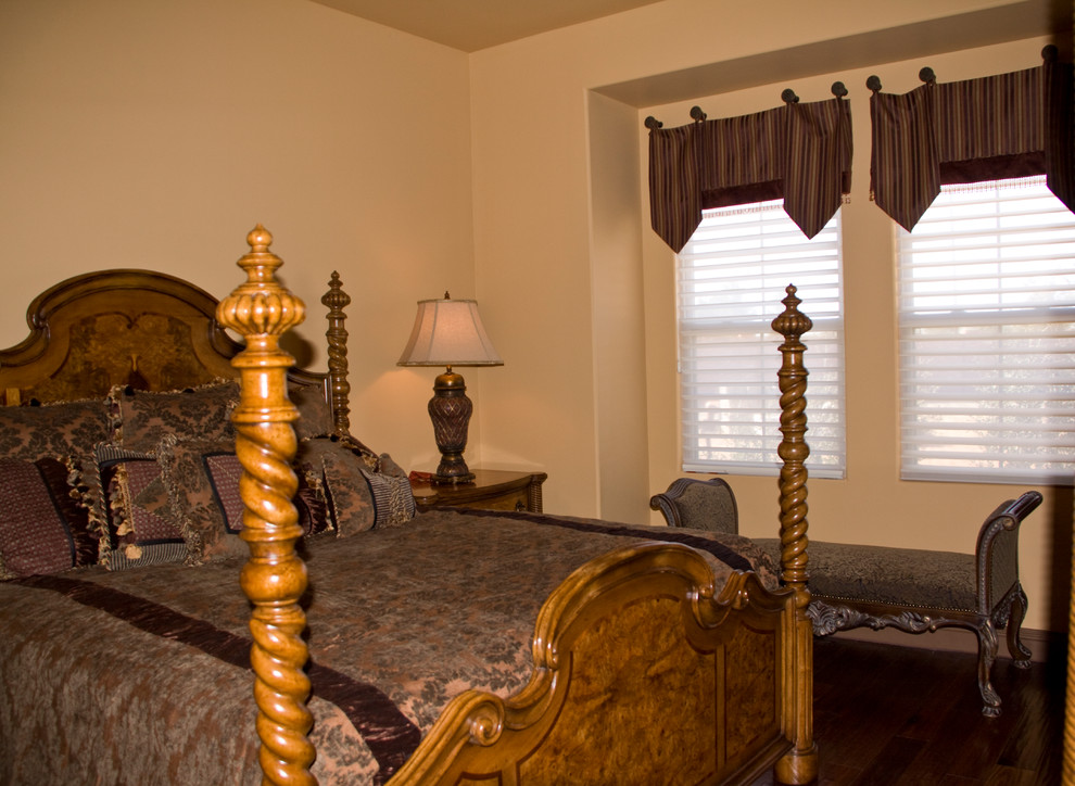 This is an example of a mid-sized mediterranean guest bedroom in Austin with beige walls and dark hardwood floors.