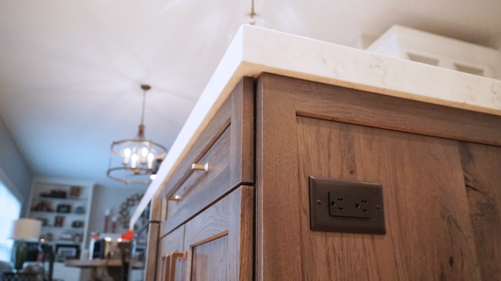 Inspiration for a transitional light wood floor open concept kitchen remodel with a farmhouse sink, recessed-panel cabinets, white cabinets, white backsplash, subway tile backsplash, stainless steel appliances, an island and white countertops