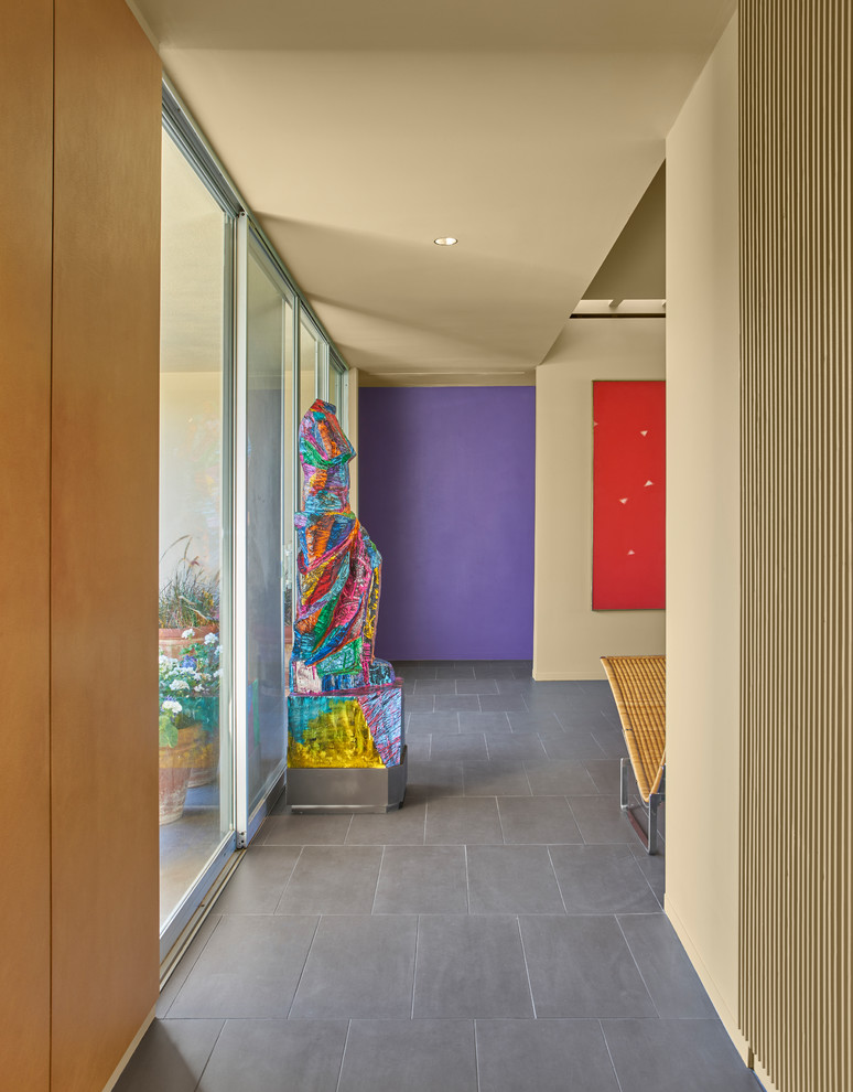 Mid-sized midcentury entryway in Chicago with beige walls, porcelain floors, a pivot front door, a purple front door and brown floor.