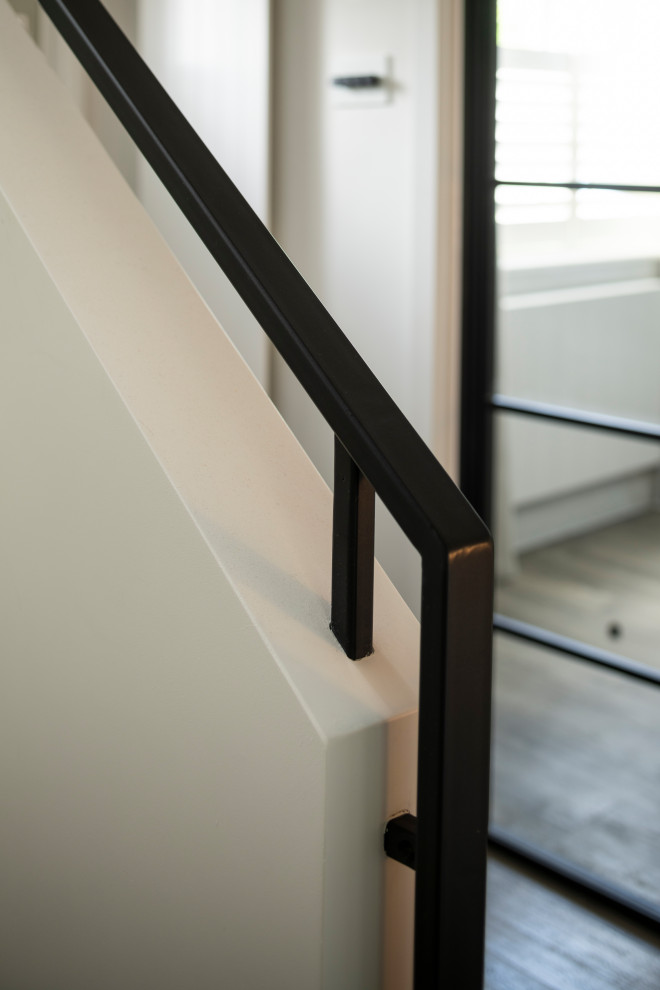 Mid-sized minimalist wooden u-shaped metal railing staircase photo with painted risers