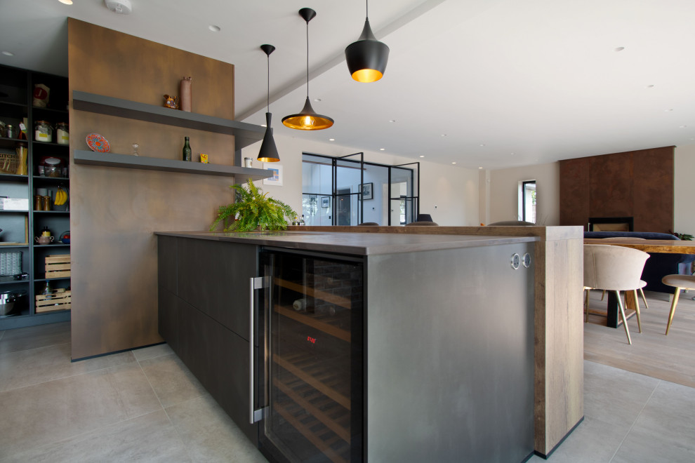 Large contemporary l-shaped open plan kitchen in Cardiff with an integrated sink, flat-panel cabinets, black cabinets, quartz benchtops, black appliances, porcelain floors, with island, grey floor and multi-coloured benchtop.
