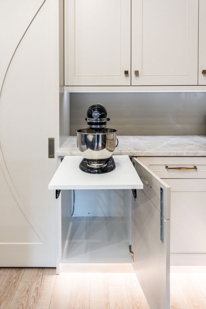 Idéer för ett mellanstort klassiskt vit kök, med en enkel diskho, luckor med infälld panel, vita skåp, bänkskiva i kvartsit, vitt stänkskydd, stänkskydd i keramik, rostfria vitvaror, vinylgolv, en köksö och beiget golv