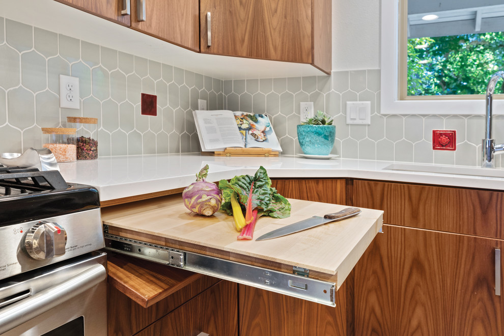 Photo of a midcentury u-shaped eat-in kitchen in Other with a single-bowl sink, flat-panel cabinets, medium wood cabinets, quartz benchtops, grey splashback, porcelain splashback, stainless steel appliances, vinyl floors and white benchtop.
