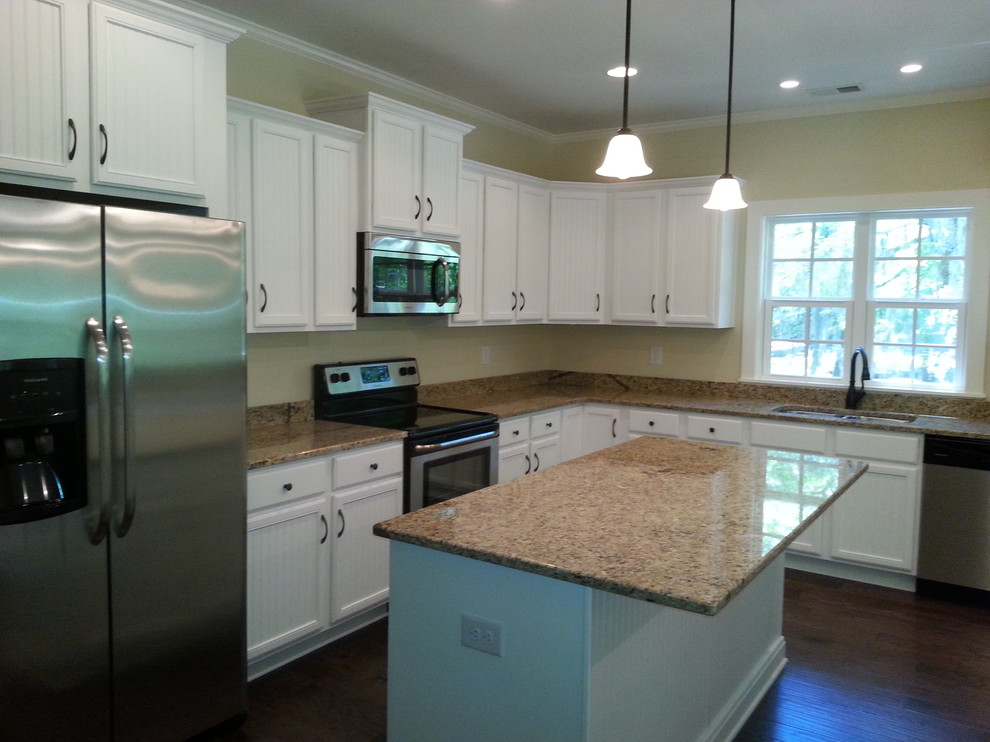 Photo of a mid-sized beach style l-shaped separate kitchen in Charleston with an undermount sink, louvered cabinets, white cabinets, granite benchtops, stainless steel appliances, dark hardwood floors and with island.