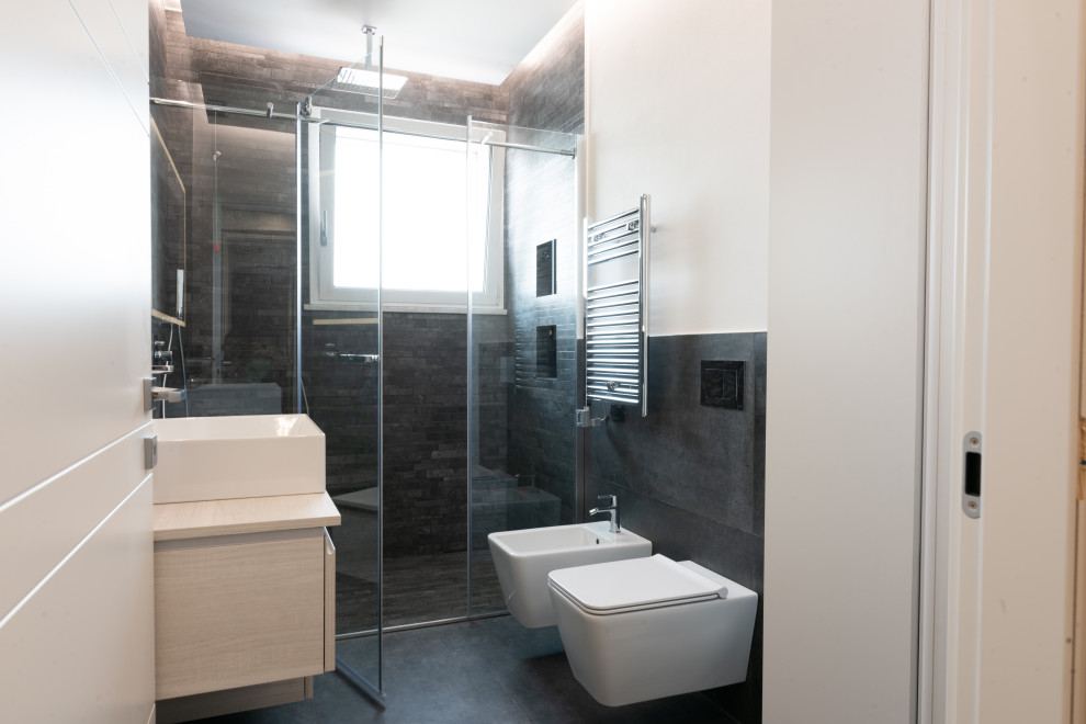 Example of a mid-sized trendy 3/4 black tile and porcelain tile porcelain tile, black floor, single-sink and tray ceiling walk-in shower design in Milan with beaded inset cabinets, beige cabinets, a wall-mount toilet, white walls, a vessel sink, laminate countertops, a hinged shower door, beige countertops, a niche and a floating vanity