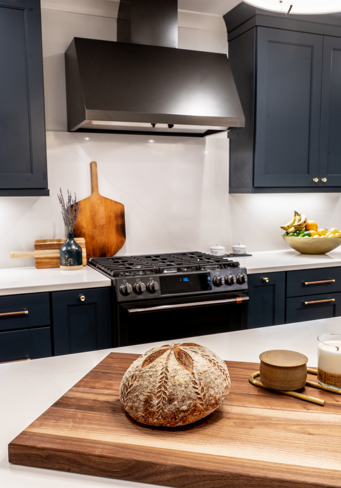 Idéer för mellanstora funkis vitt kök, med en undermonterad diskho, skåp i shakerstil, blå skåp, bänkskiva i kvarts, vitt stänkskydd, svarta vitvaror, mellanmörkt trägolv, en köksö och flerfärgat golv