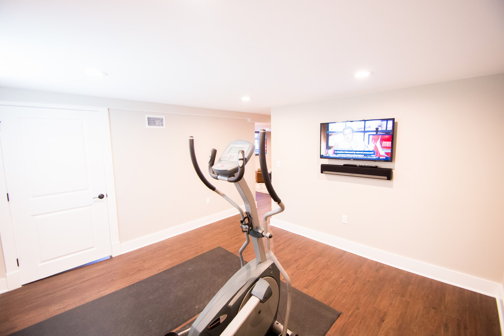 Design ideas for a mid-sized contemporary home weight room in New York with beige walls and medium hardwood floors.