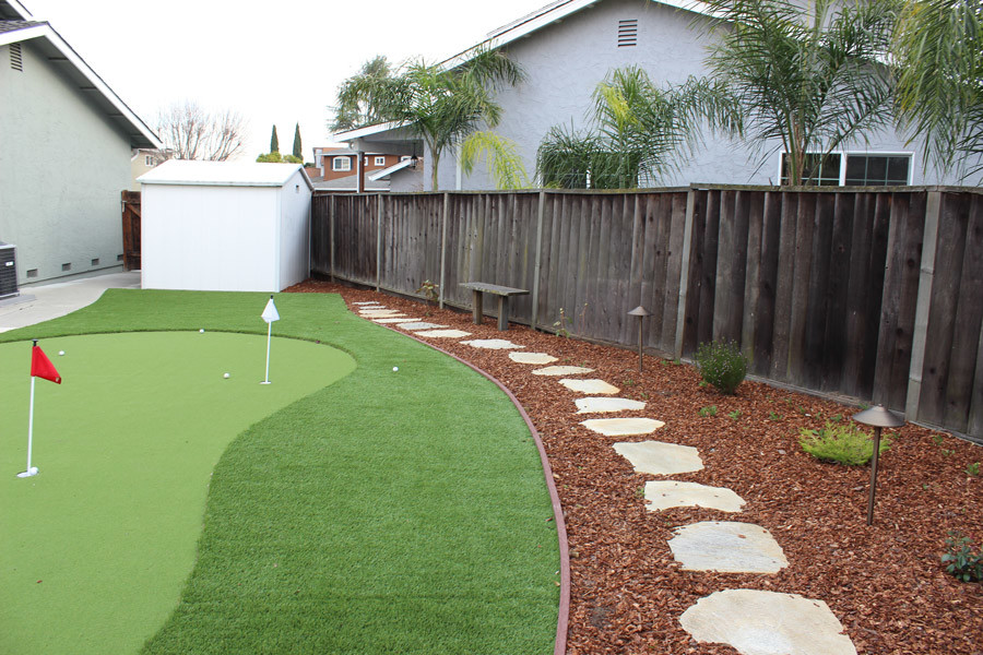 Photo of a mid-sized traditional backyard full sun outdoor sport court in San Francisco with natural stone pavers.