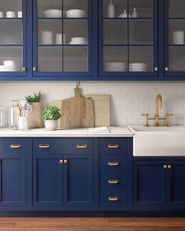Inspiration for a mid-sized transitional single-wall medium tone wood floor and brown floor eat-in kitchen remodel in Columbus with a farmhouse sink, recessed-panel cabinets, blue cabinets, marble countertops, white backsplash, ceramic backsplash, stainless steel appliances and white countertops